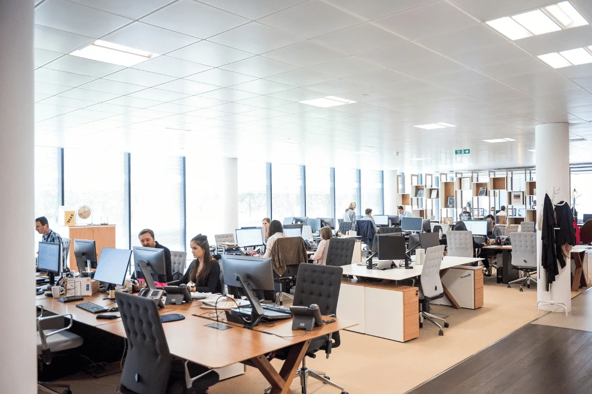 Open-plan office with employees working at desks.