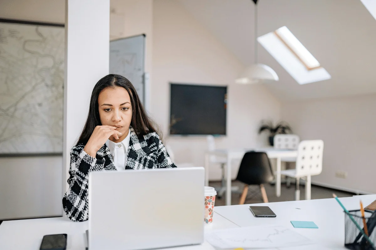 Businesswoman working on a laptop in a modern office workspace.