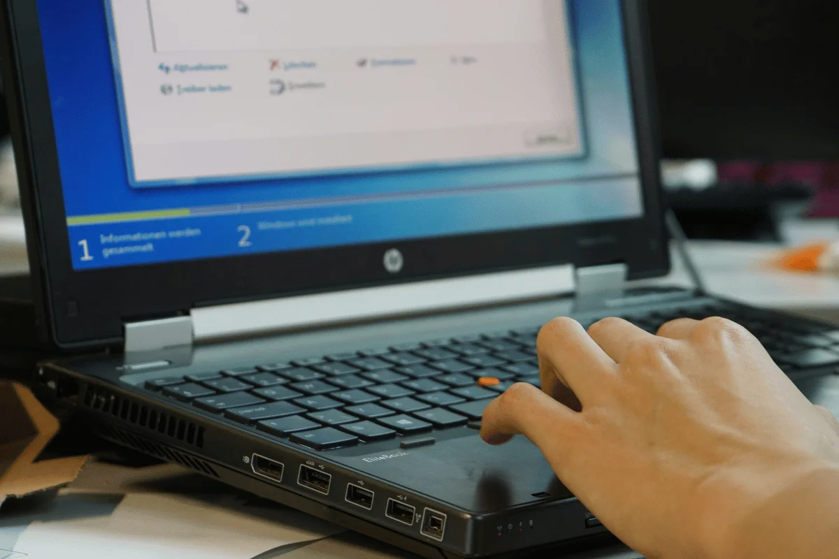 User interacting with laptop while installing software program.