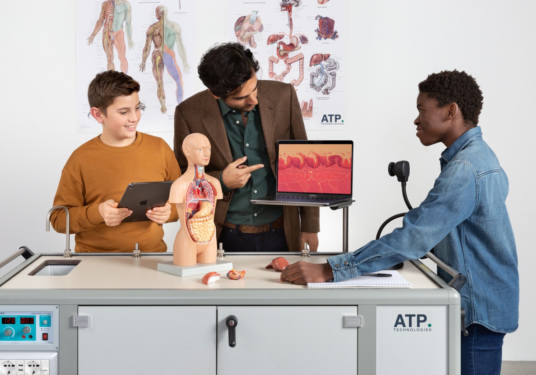 Un docente e alcuni studenti che esaminano un modello anatomico accanto al laboratorio mobile ATP