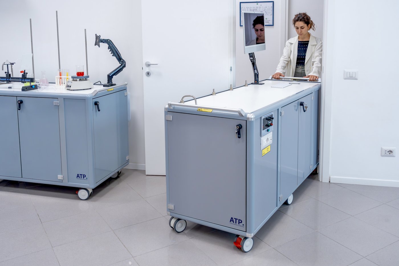A teacher rolling an ATP mobile laboratory into a classroom