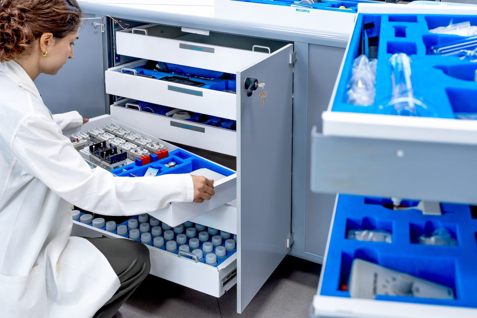 Un technicien ouvre en coulissant un tiroir portant l'étiquette « Smart Tray » dans l'armoire « ATP Mobile Lab », l'équipement étant calé dans de la mousse bleue moulée
