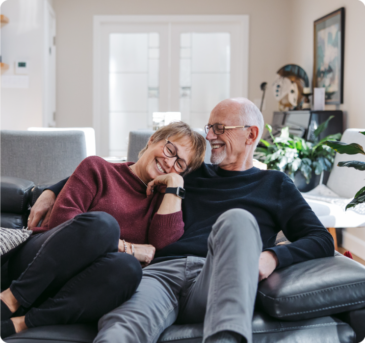 A man and woman on couch leaning on each other