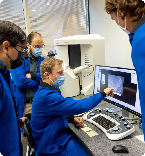 Scientists and engineers standing around computer