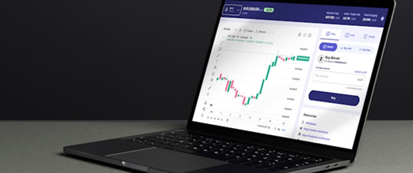 Laptop displaying a financial trading platform with a stock chart and buy options.