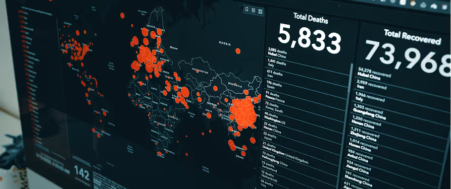 Digital dashboard showing a world map with red circles indicating COVID-19 case concentrations and panels displaying total deaths and total recovered statistics.