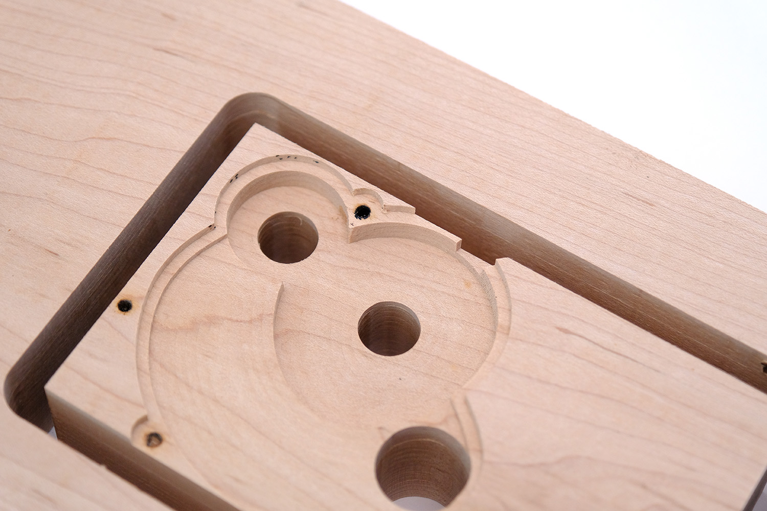 Close up photograph of wood CNC cut showing an encasing for gears. 