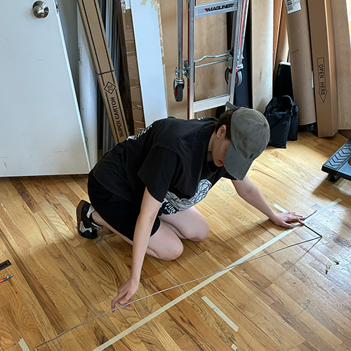 Photo of me measuring the length of our helix on the floor. 