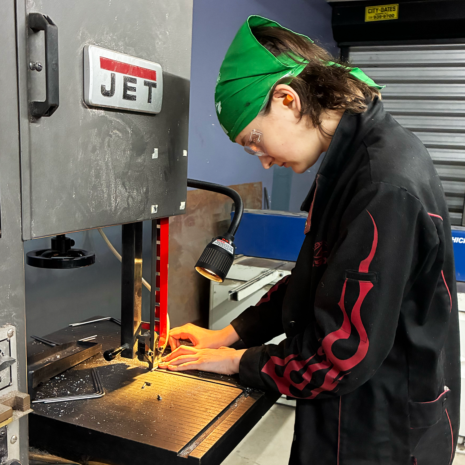 Photo of me cutting small metal pieces on the bandsaw to form the weights of the bird bodies. 