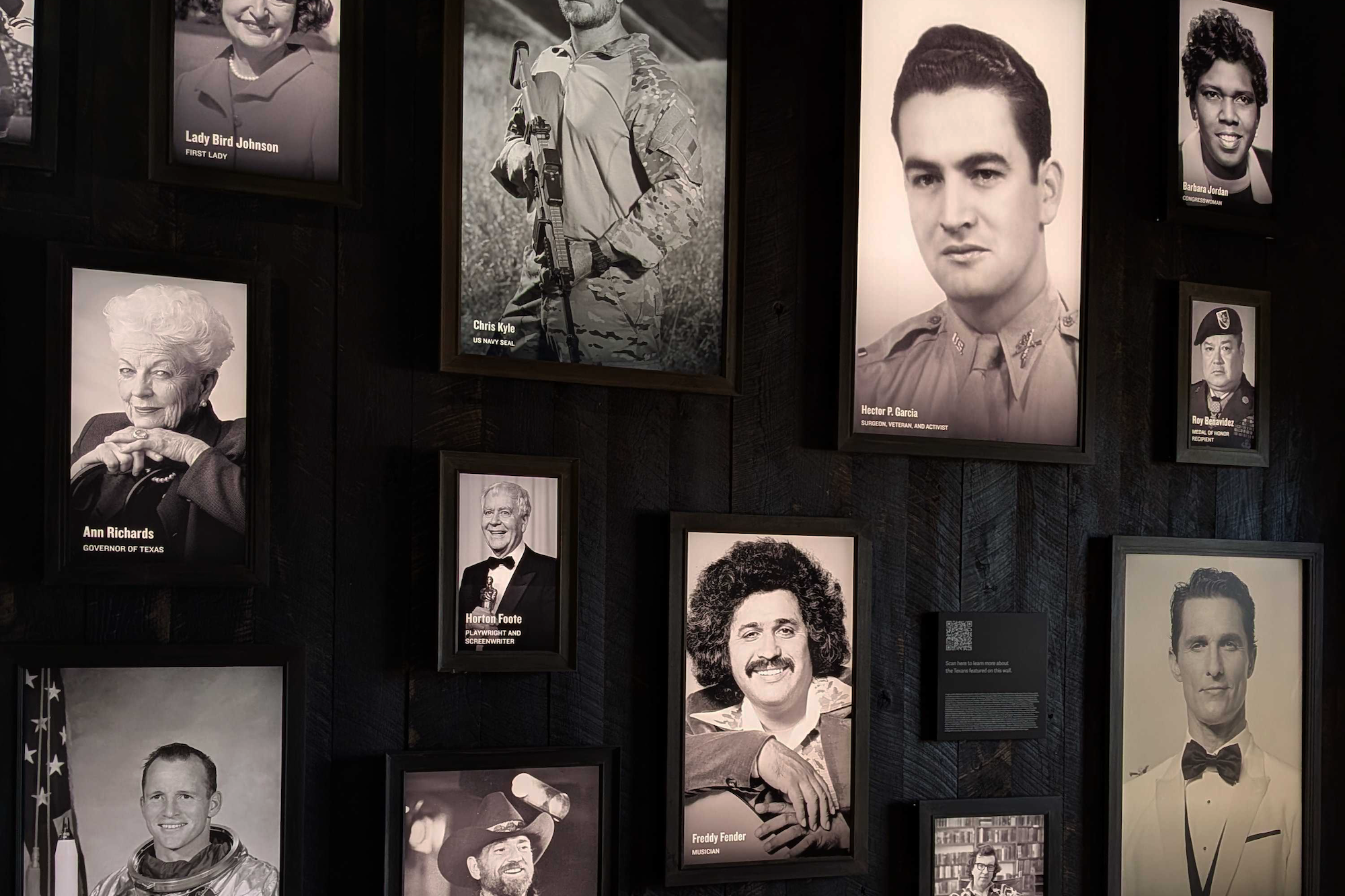 Wall display of framed black-and-white portraits of notable Texans.