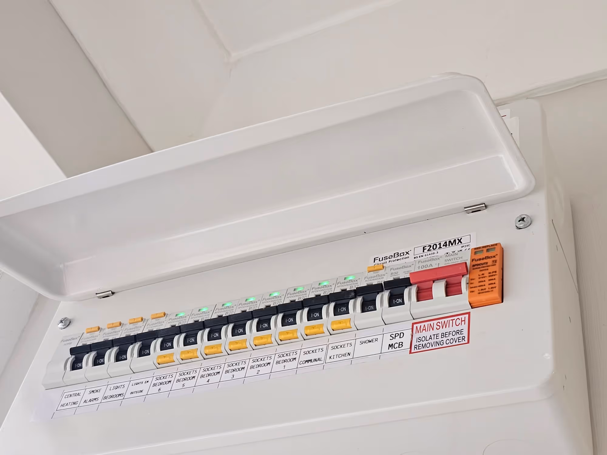 Electrical fuse box with multiple labelled switches and circuit breakers, including main switch and socket controls.