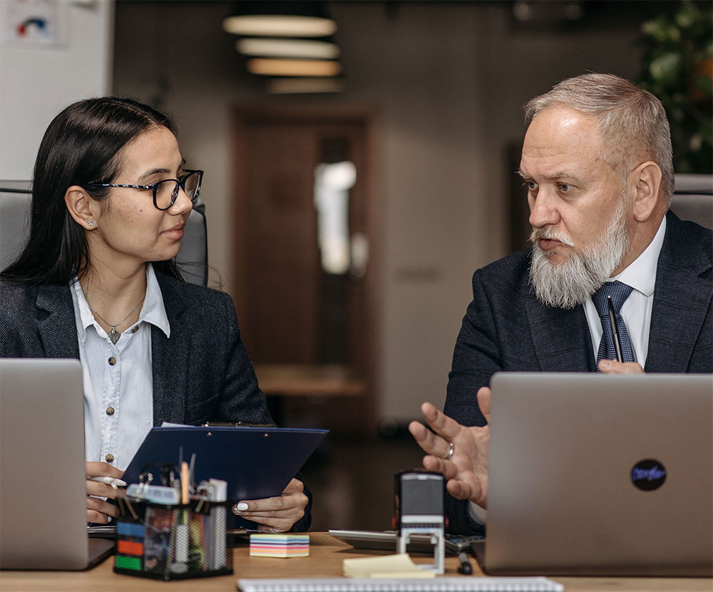 A leadership development consultant discusses executive training with a woman