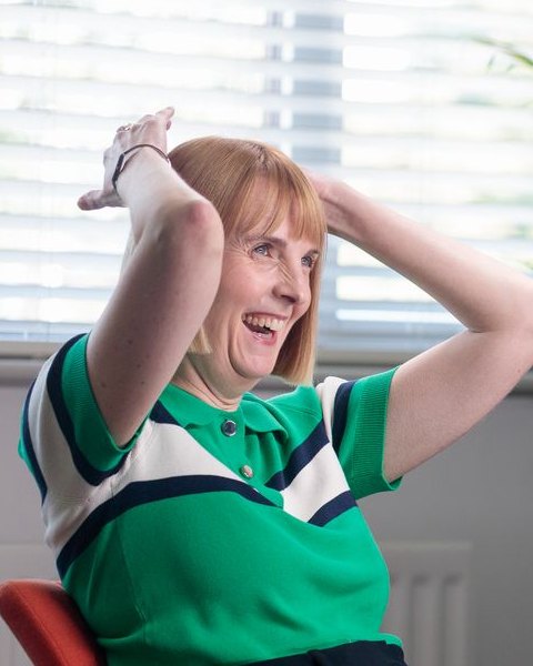 Rhi Baxter of We Are Brave laughing with her hands on her head on the filming day