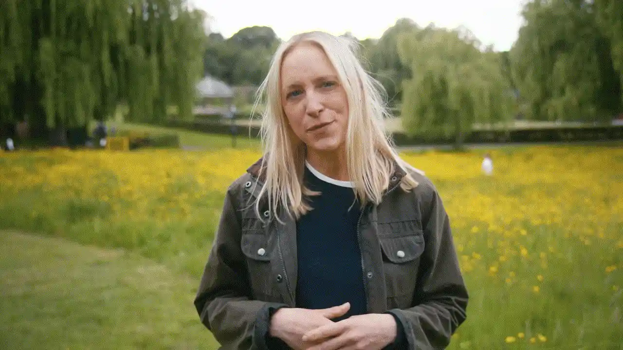 A presenter standing in a meadow of buttercups in Godalming.