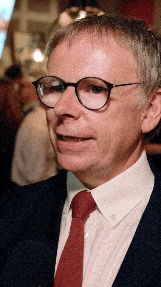 A man in glasses being interviewed at an event.