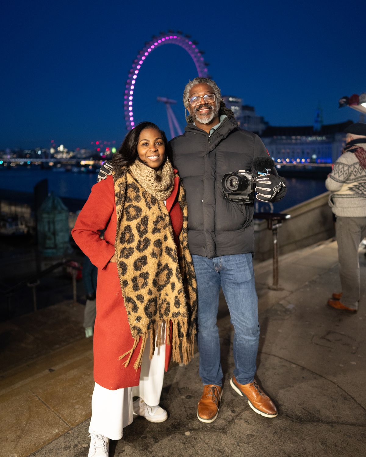 Kevan and Mecca Perry smiling at the camera on the South Bank at night, the London Eye lit behind them, January 2025