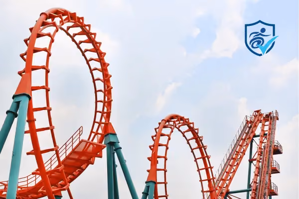 Photo of two loops of an orange and turquoise rollercoaster.