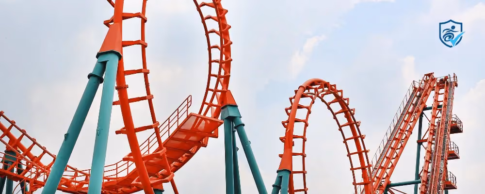 Photo of two loops of an orange and turquoise rollercoaster.