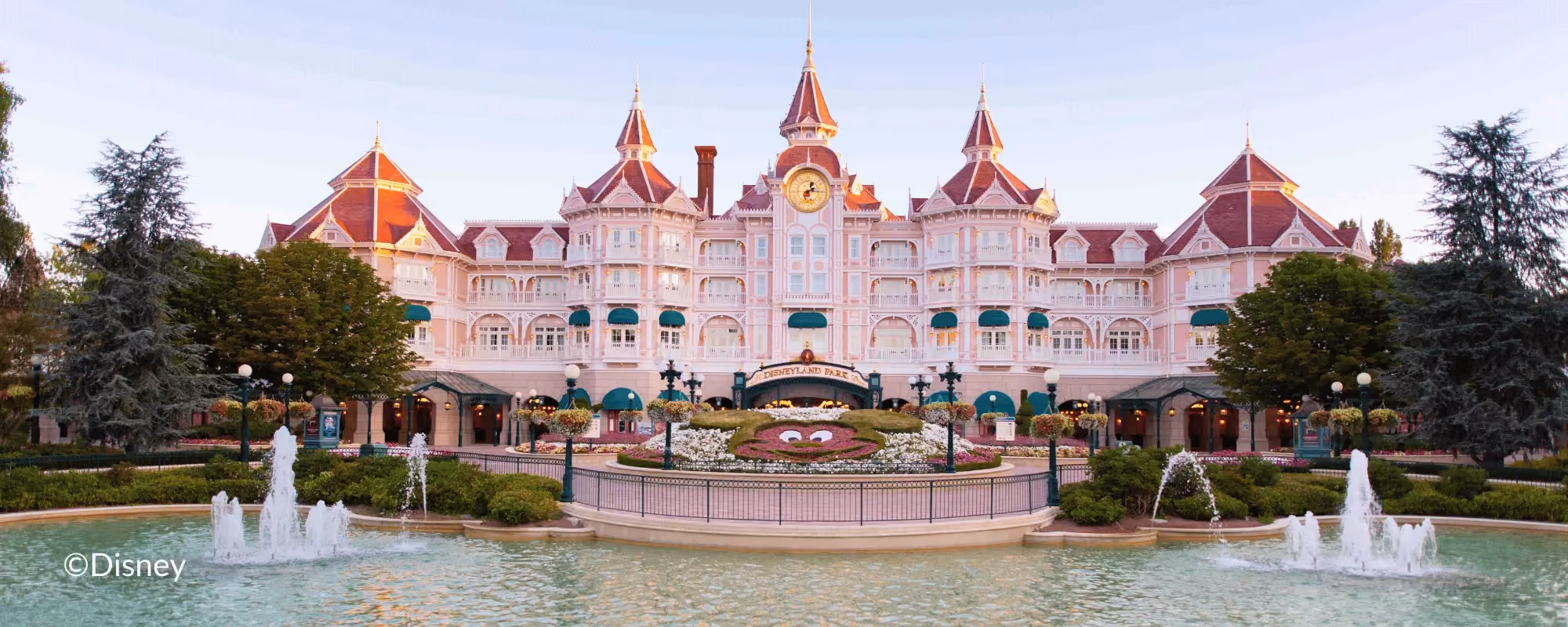 Photo of the Disneyland Paris hotel with pool and fountain in front of it.