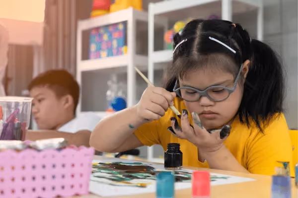 Disabled child doing finger painting