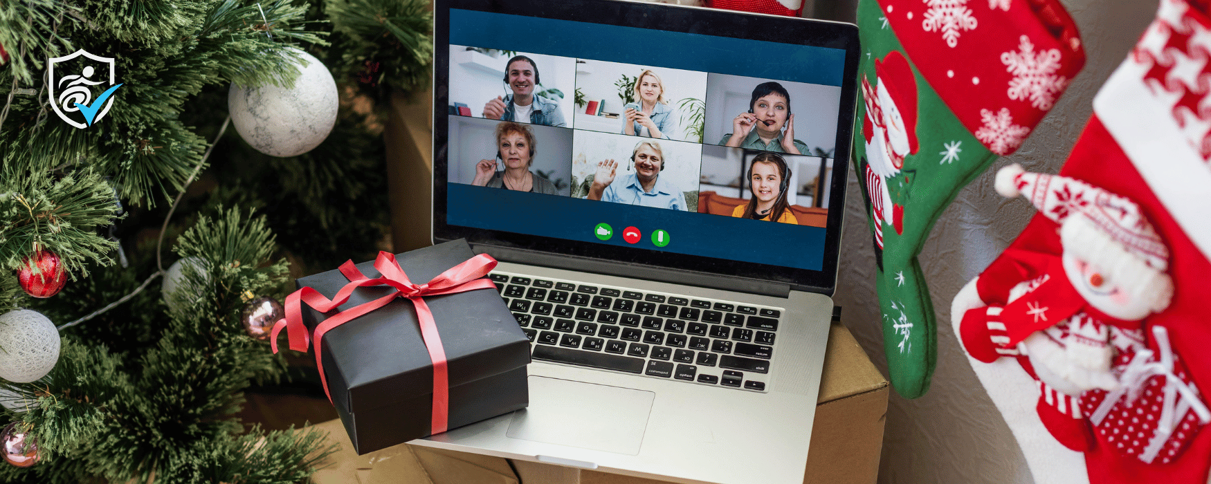 A laptop open on facetime next to a christmas tree and stockings