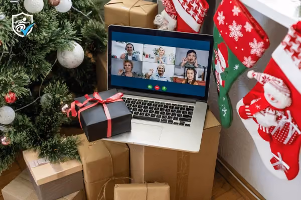 A laptop open on facetime next to a christmas tree and stockings