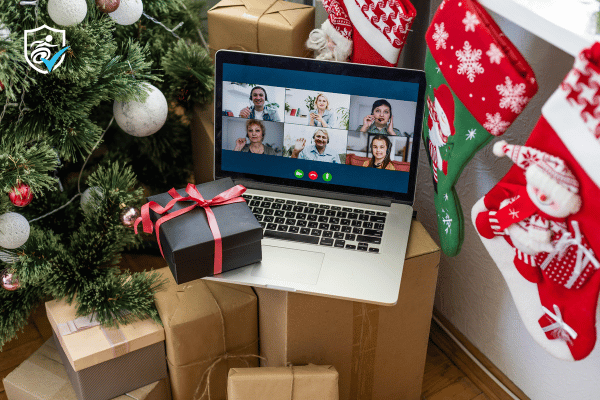 A laptop open on facetime next to a christmas tree and stockings