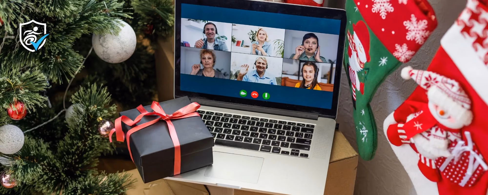 A laptop open on facetime next to a christmas tree and stockings