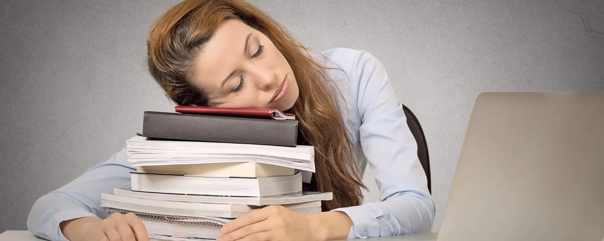 Woman asleep on top of paperwork 