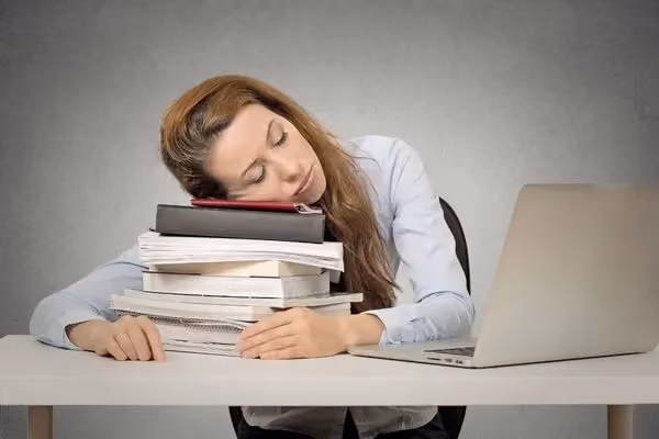 Woman asleep on top of paperwork