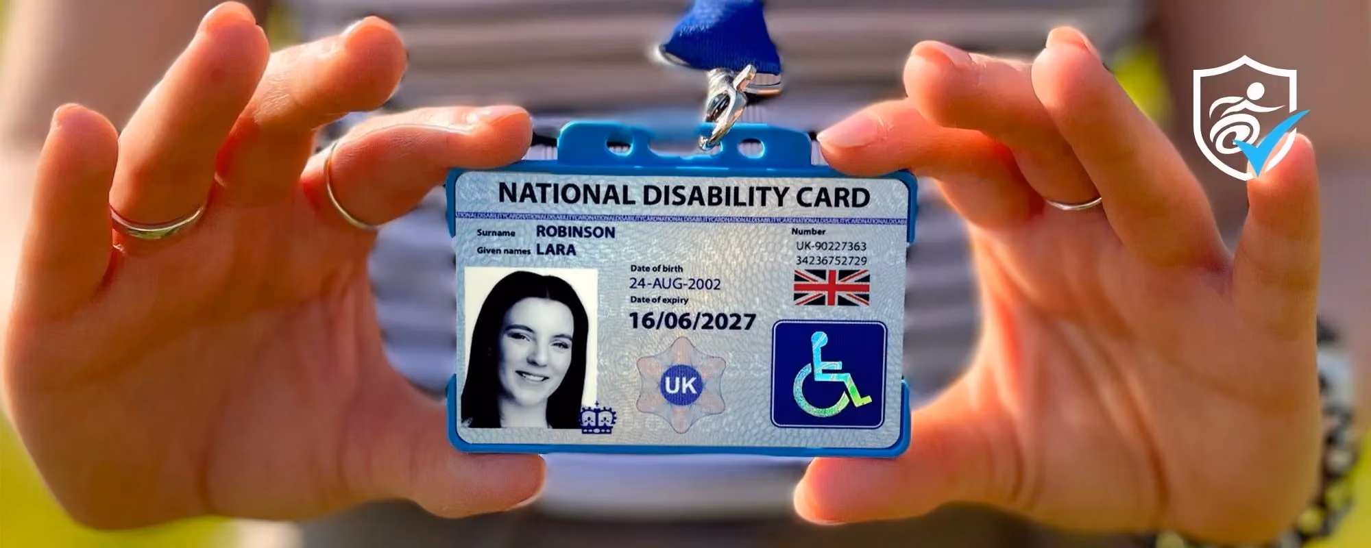 Close up photo of the National Disability Card being held by two hands