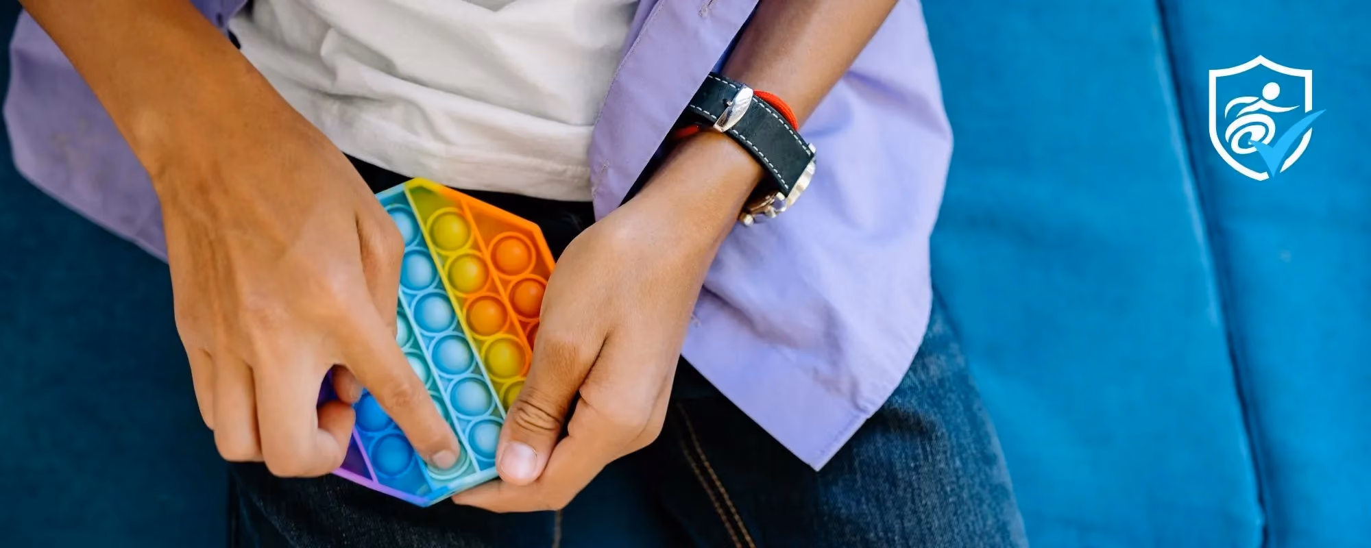 A photo of a person's hands holding a coloured stress relief tool from above