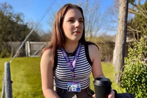 Lara wearing a lanyard and National Disability Card 