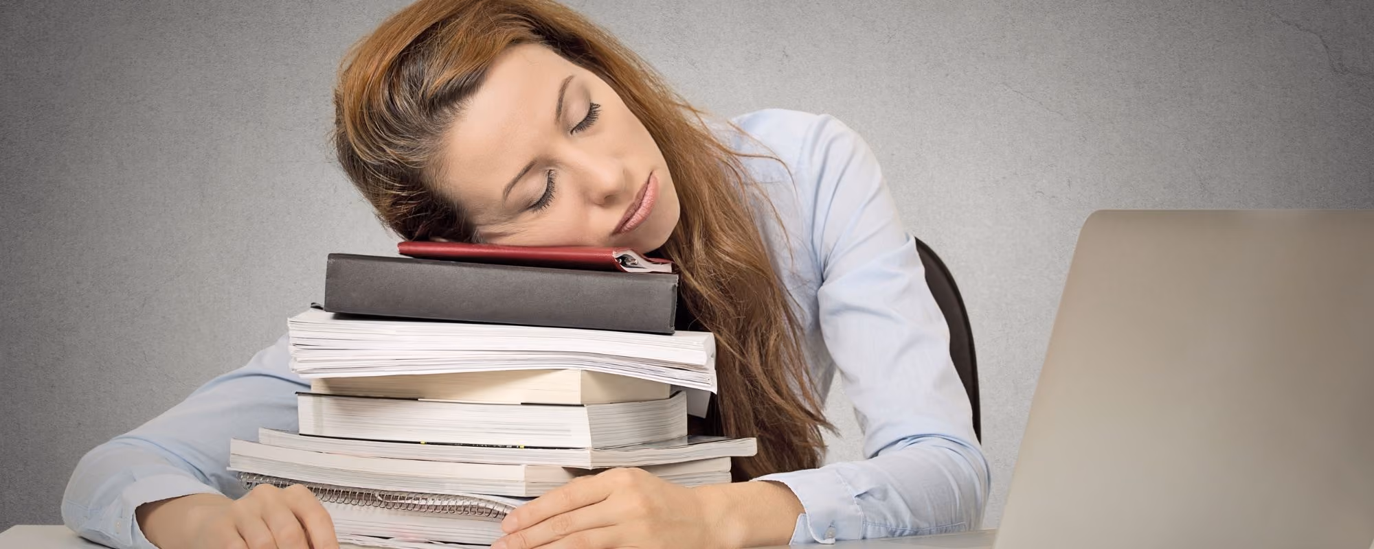Woman asleep on top of paperwork