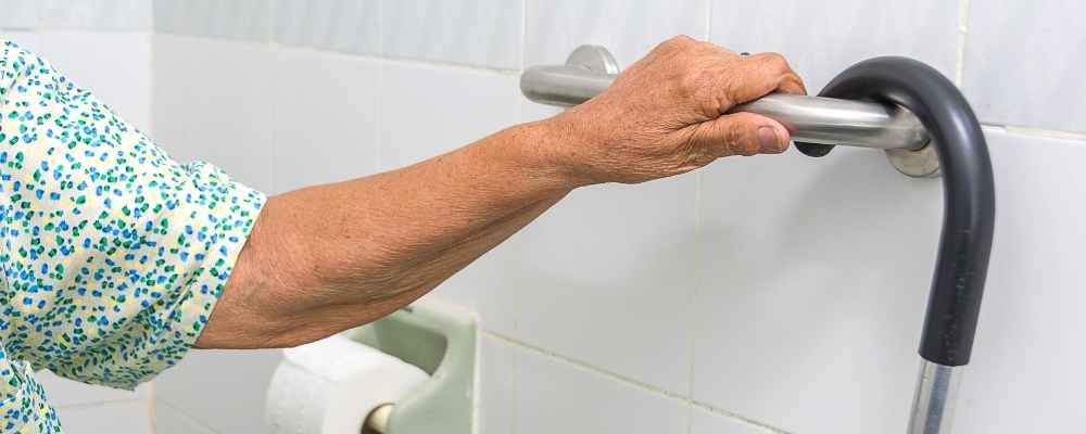 photo of a person's arm holding a bathroom rail