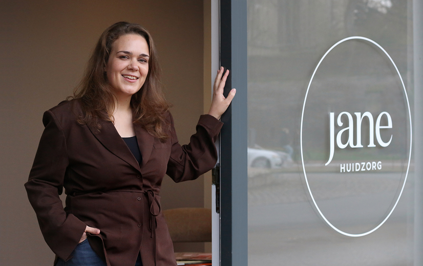 Jane bij de ingang van Jane Huidzorg.