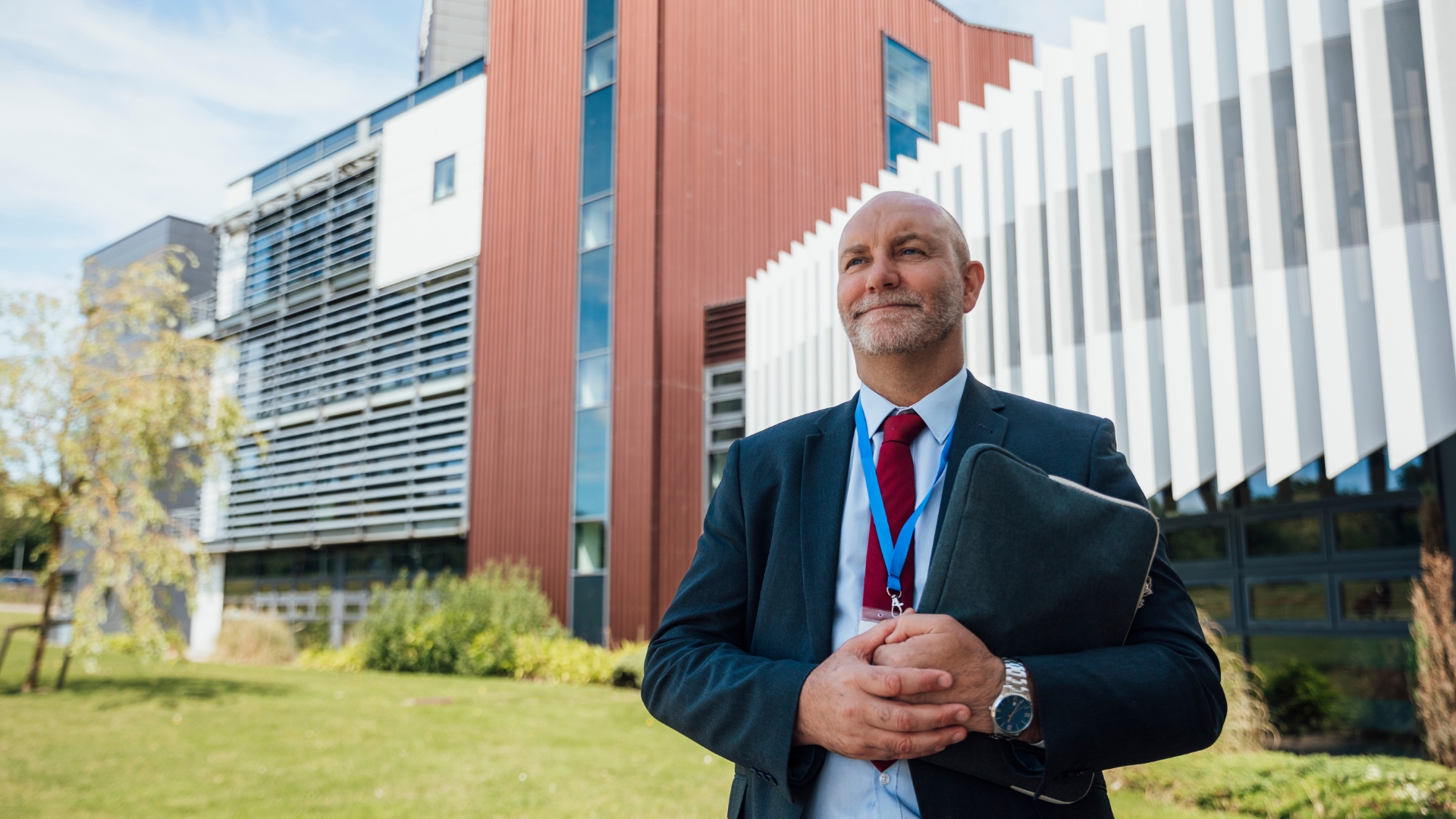 School principal standing outside school building representing data-driven school leadership and portfolio pedagogy implementation