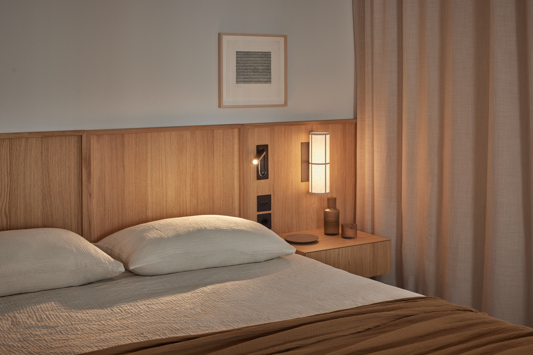 Schlafzimmer Josefstrasse — warmes Wandleuchten-Licht auf Eiche