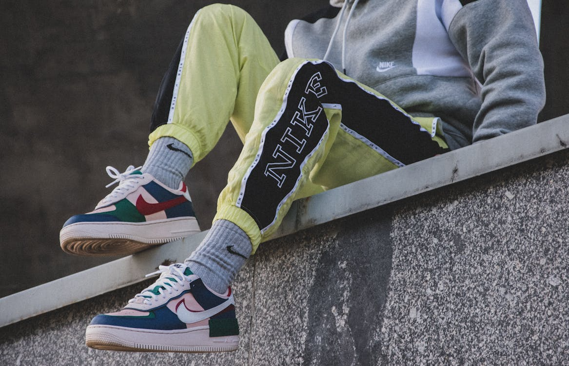 Person sat on a wall in Nike tracksuit
