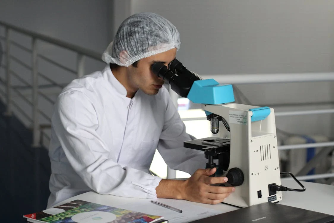 Medical professional looking through microscope