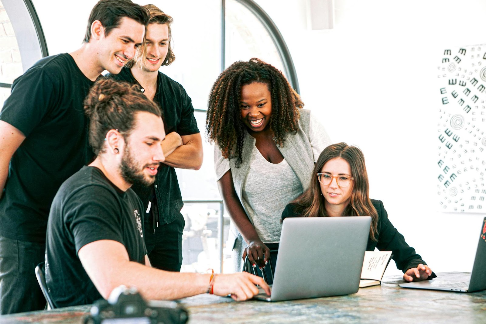 A group of people looking at a laptop