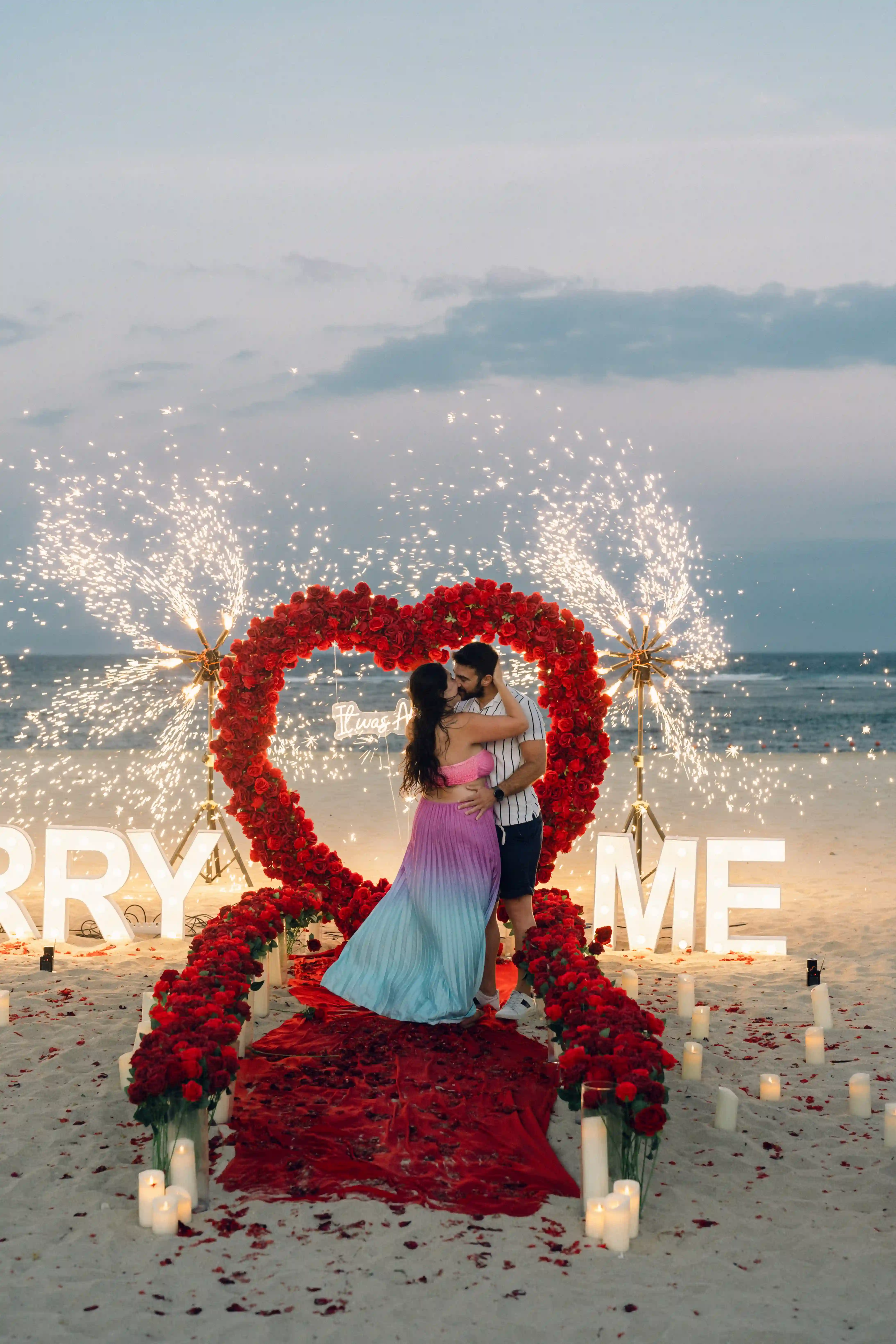 beach proposal in Bali flower arch and pyrotechnics