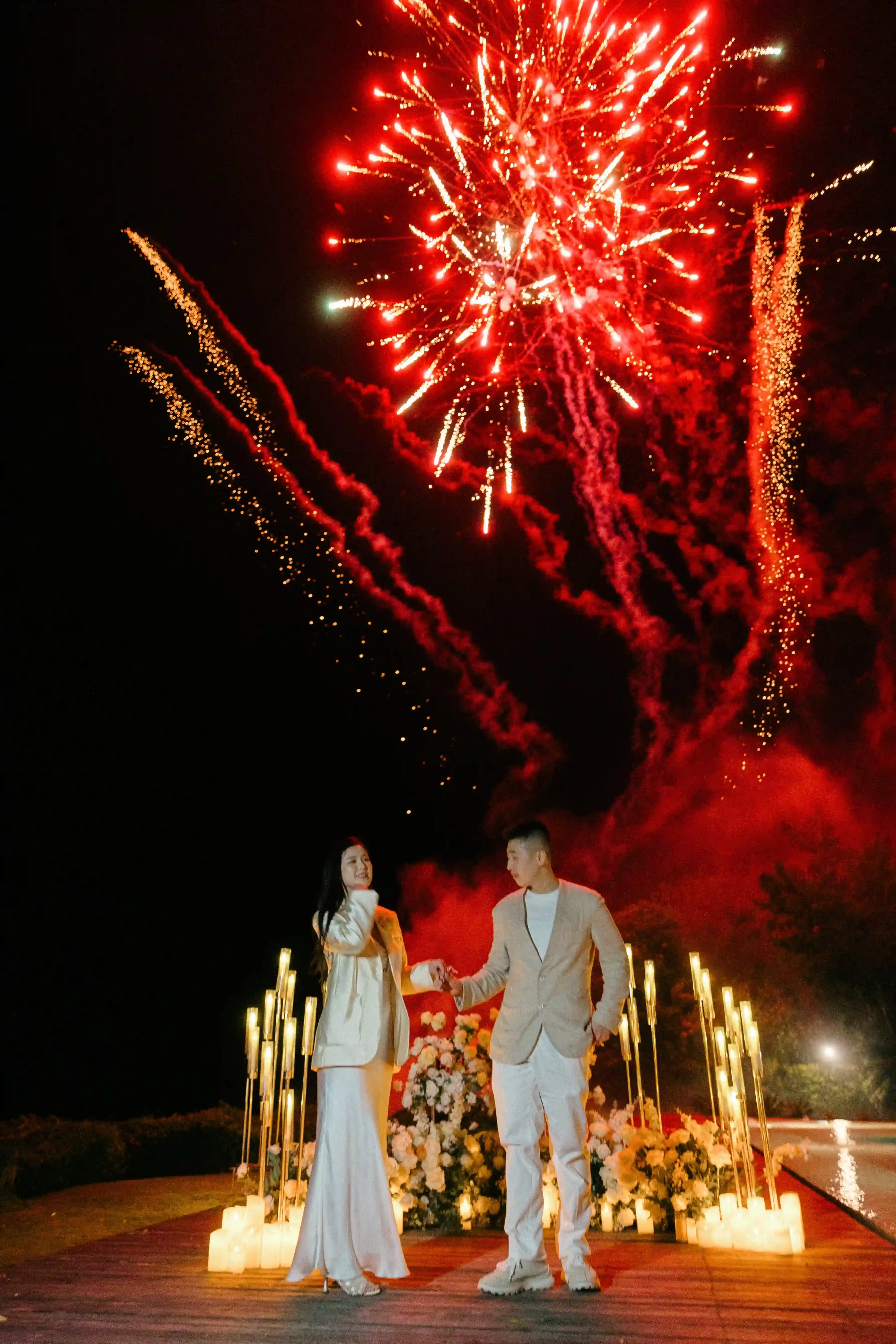 beach proposal in Bali flower arch and pyrotechnics