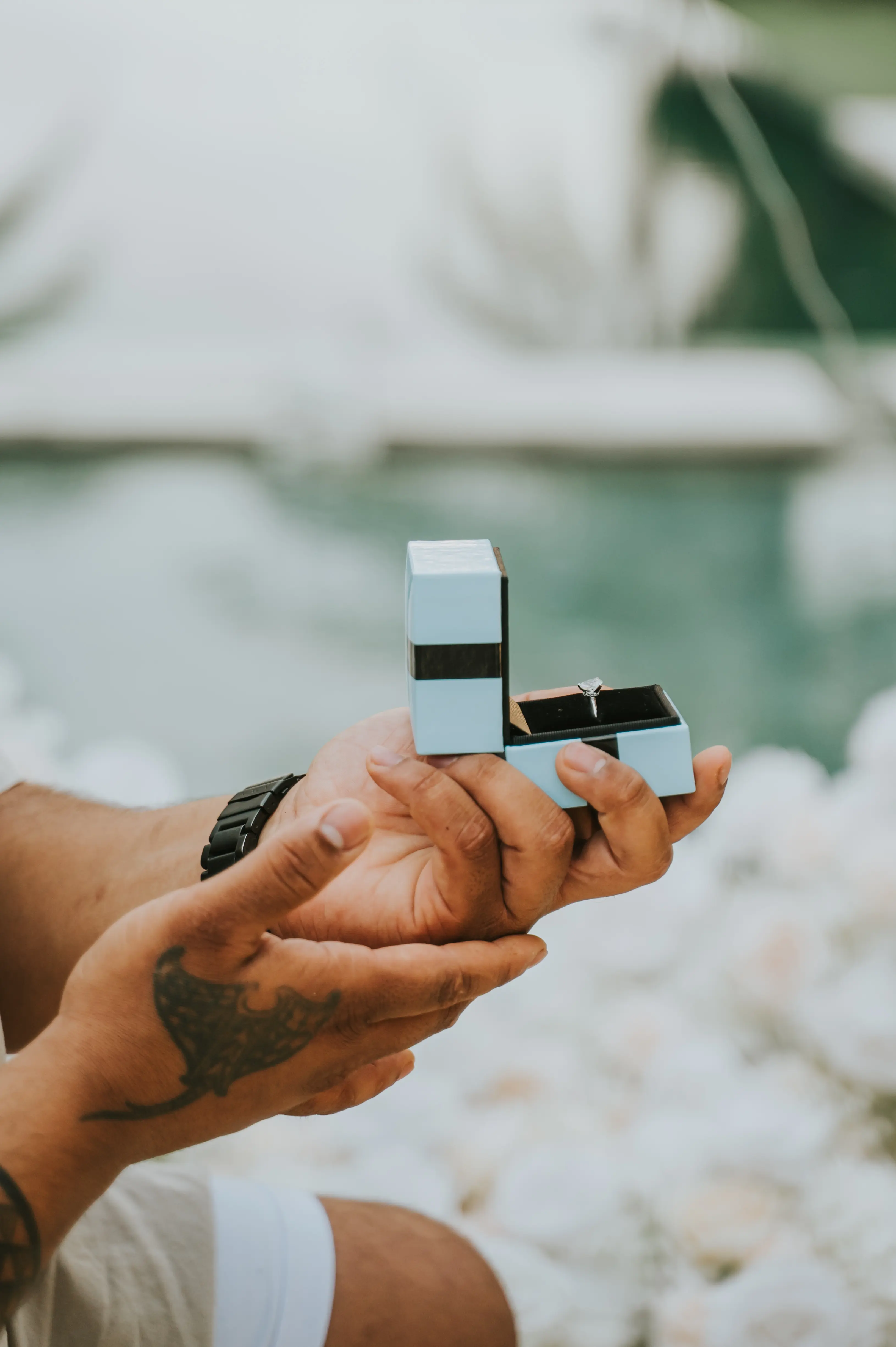 Man holding ring box during Bali proposal at sunset