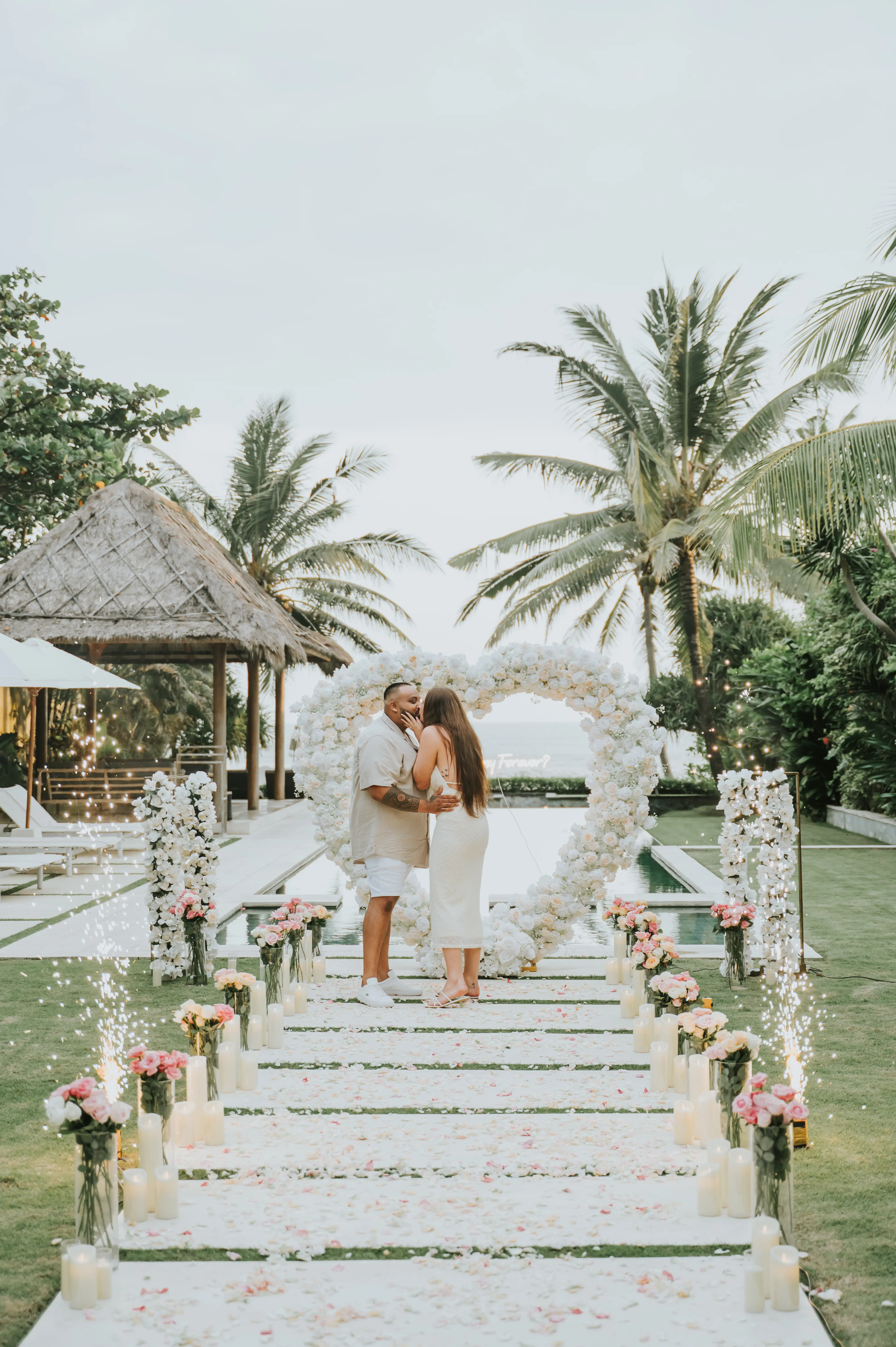 Surprise villa proposal in Bali with flower arch and tropical scenery