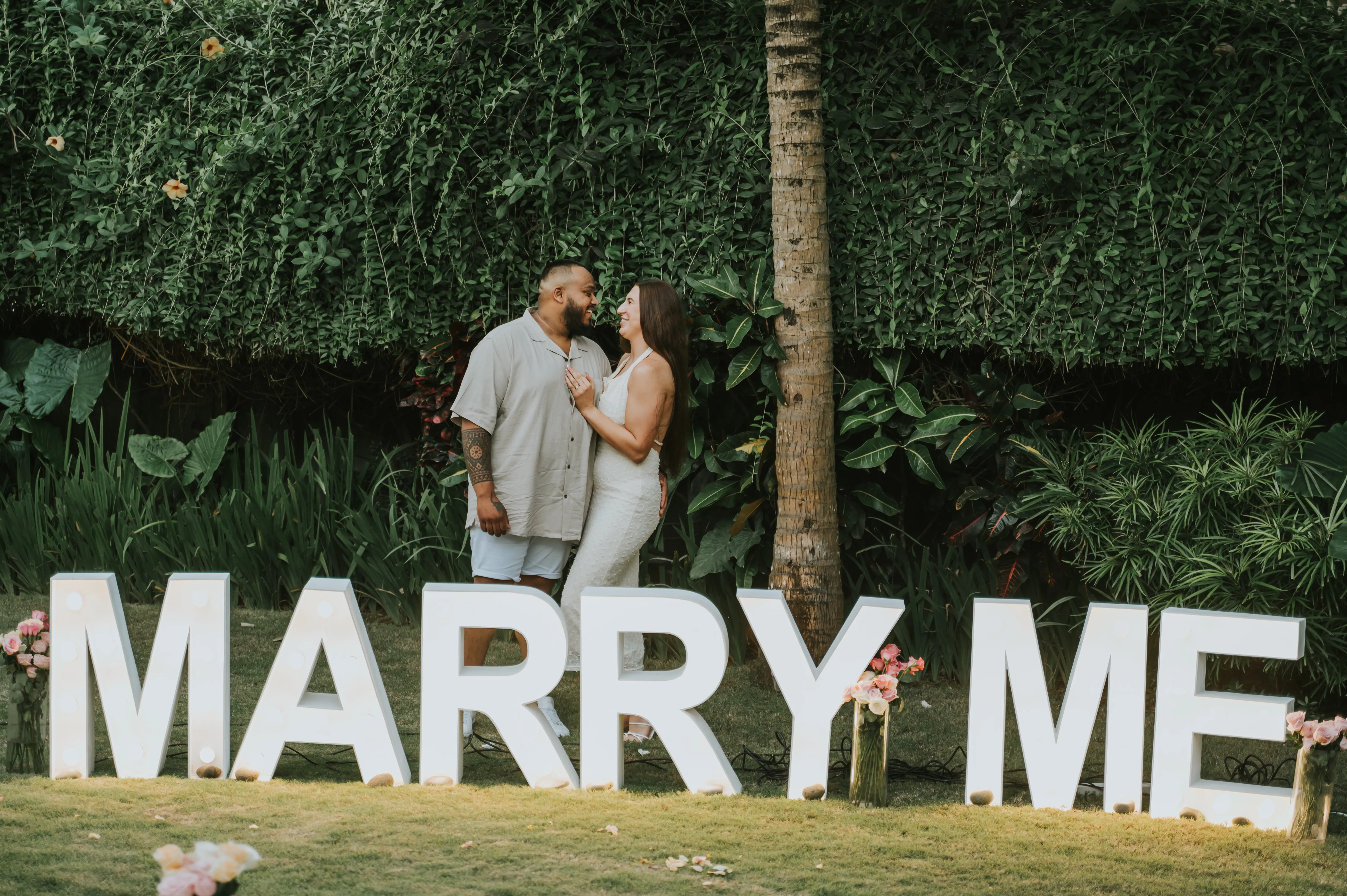 Couple engagement moment in front of Marry Me sign in Bali villa