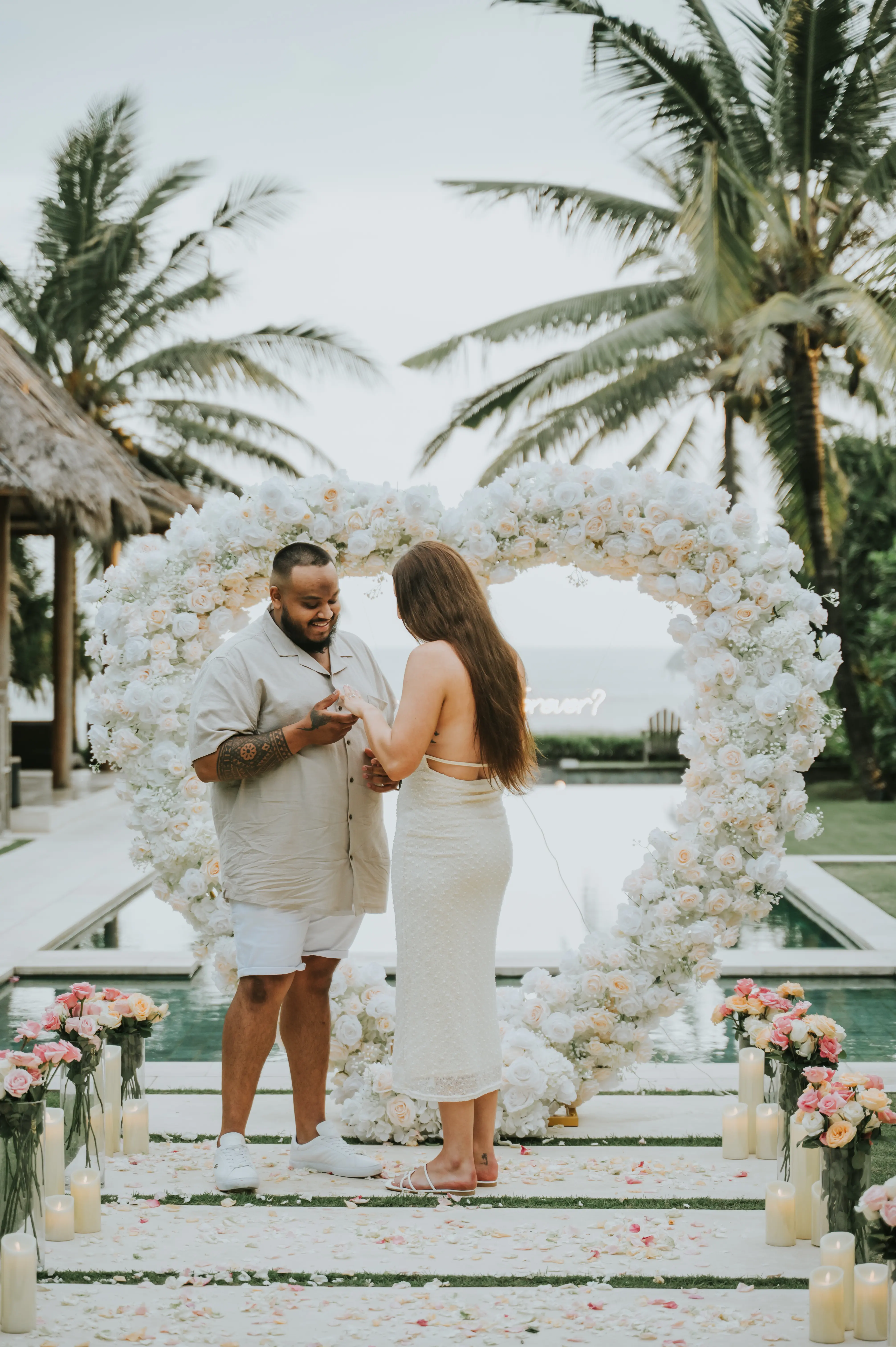 Surprise Bali proposal with palm trees and Marry Me sign in tropical garden