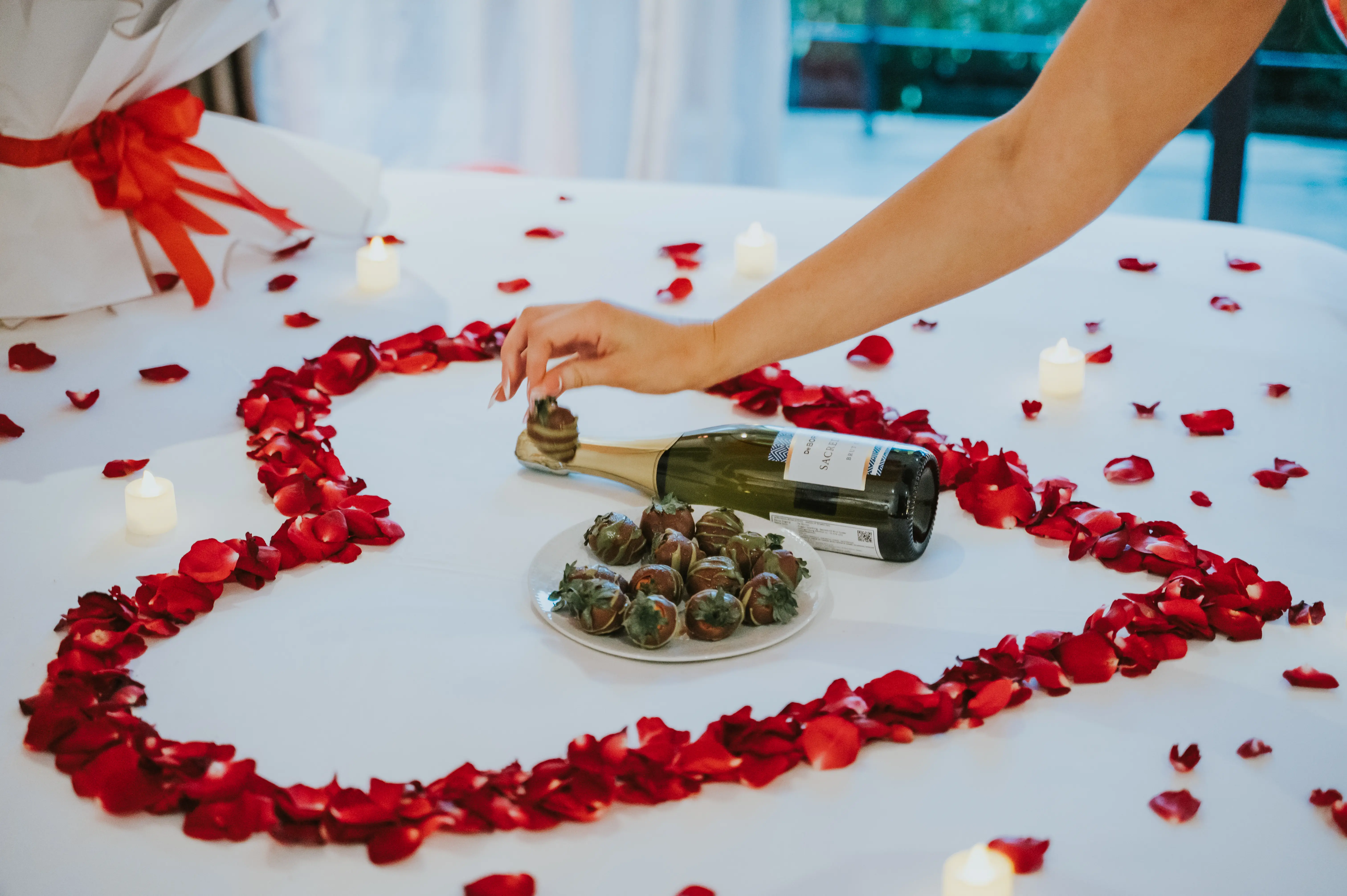 Heart-shaped rose petals on bed for Bali proposal setup