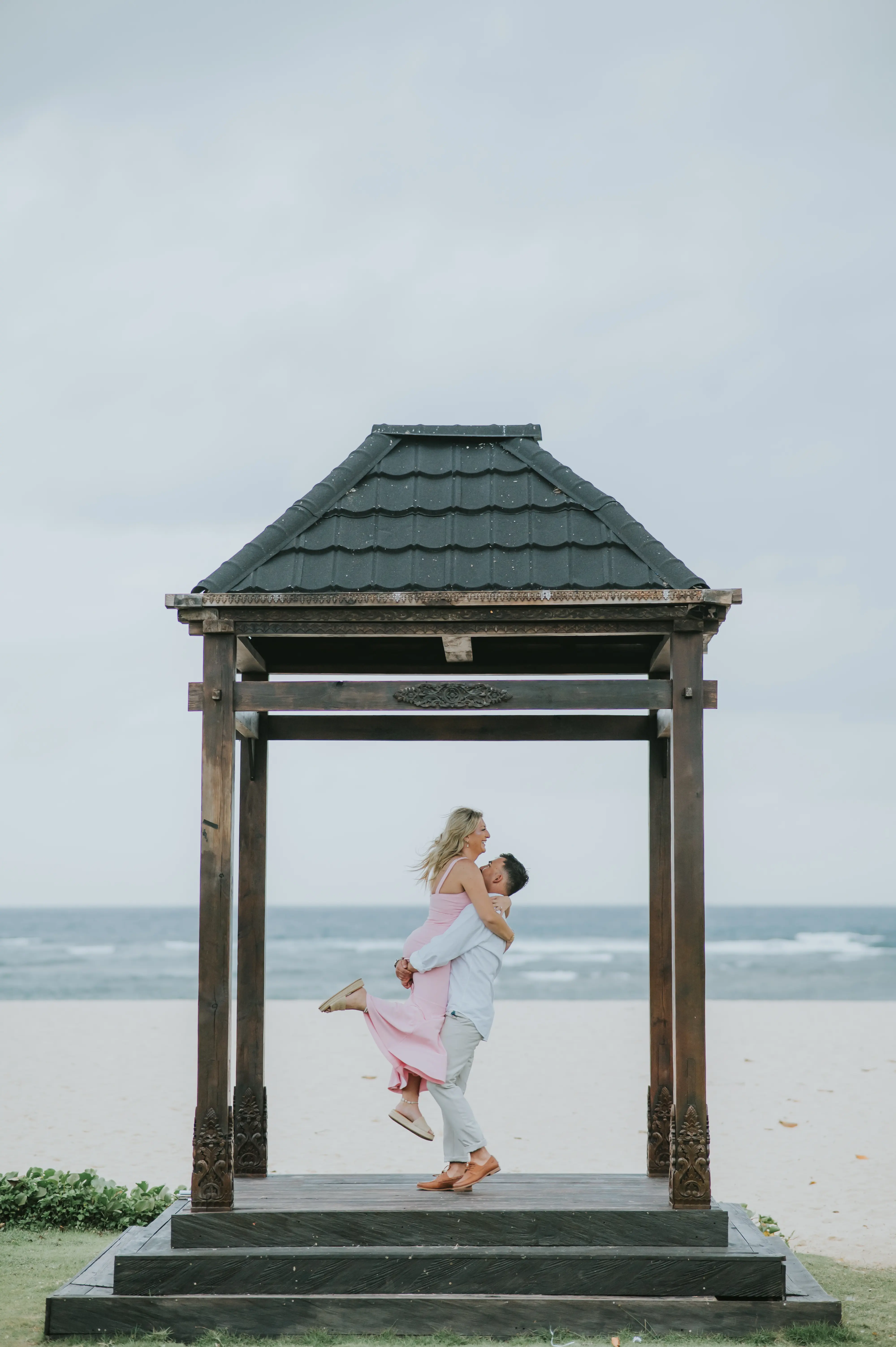 Couple photoshoot at Bali beach pavilion with elegant proposal decor