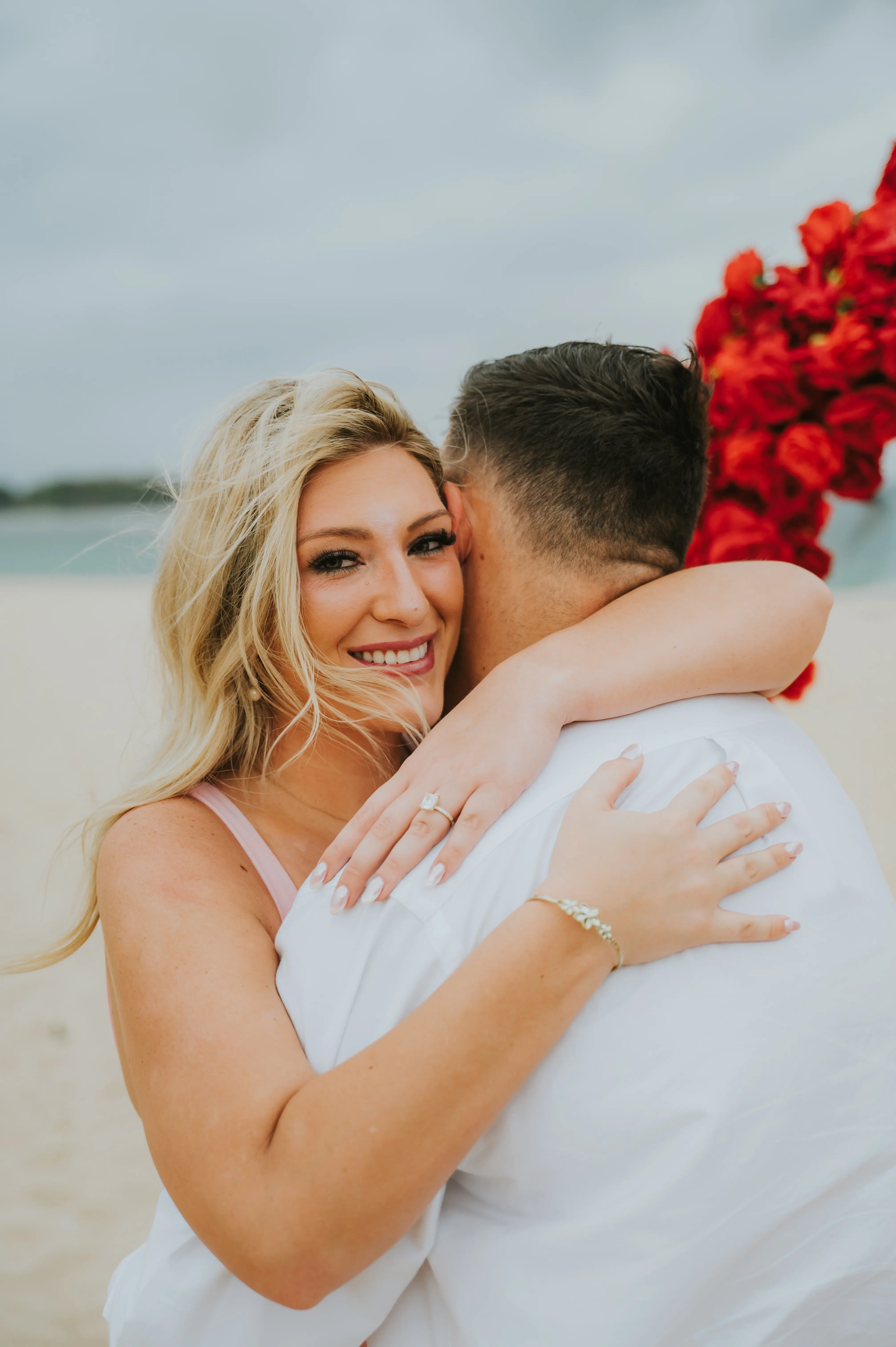 Just engaged couple smiling in front of beachside rose heart in Bali
